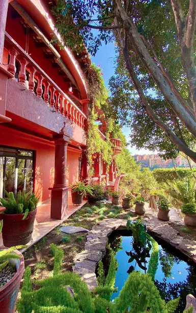Casa Puesta del Sol, red facade with balconies above the garden, San Miguel de Allende