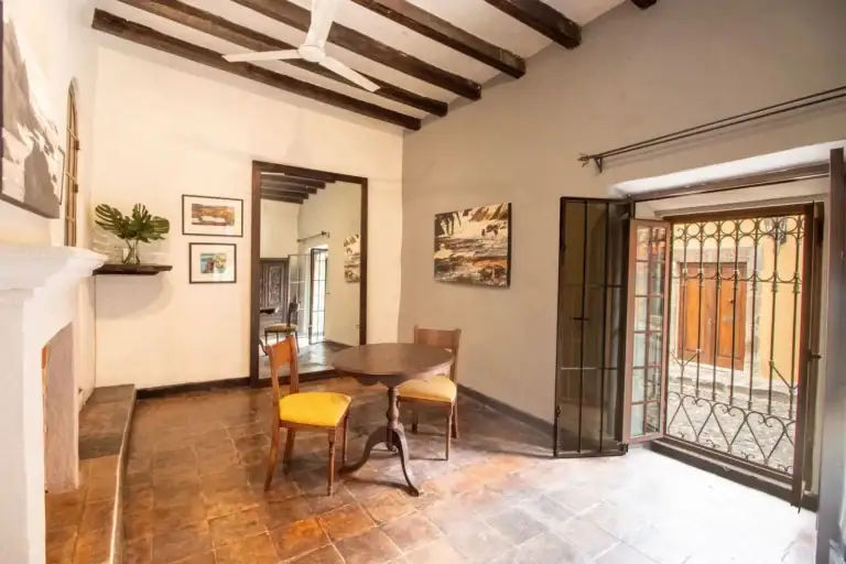 Casa Quetzal Hotel, suite living area with a dining table, yellow chairs and a beamed ceiling, San Miguel de Allende
