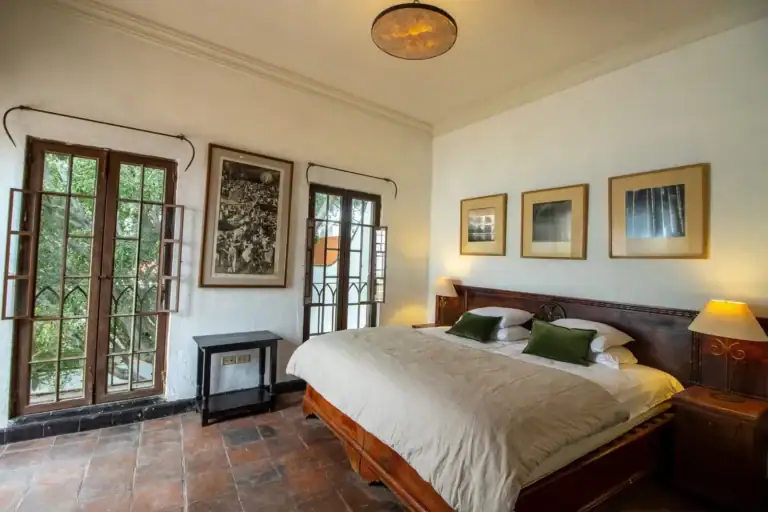 Casa Quetzal Hotel, bedroom with French doors to the garden and a carved wooden bed, San Miguel de Allende