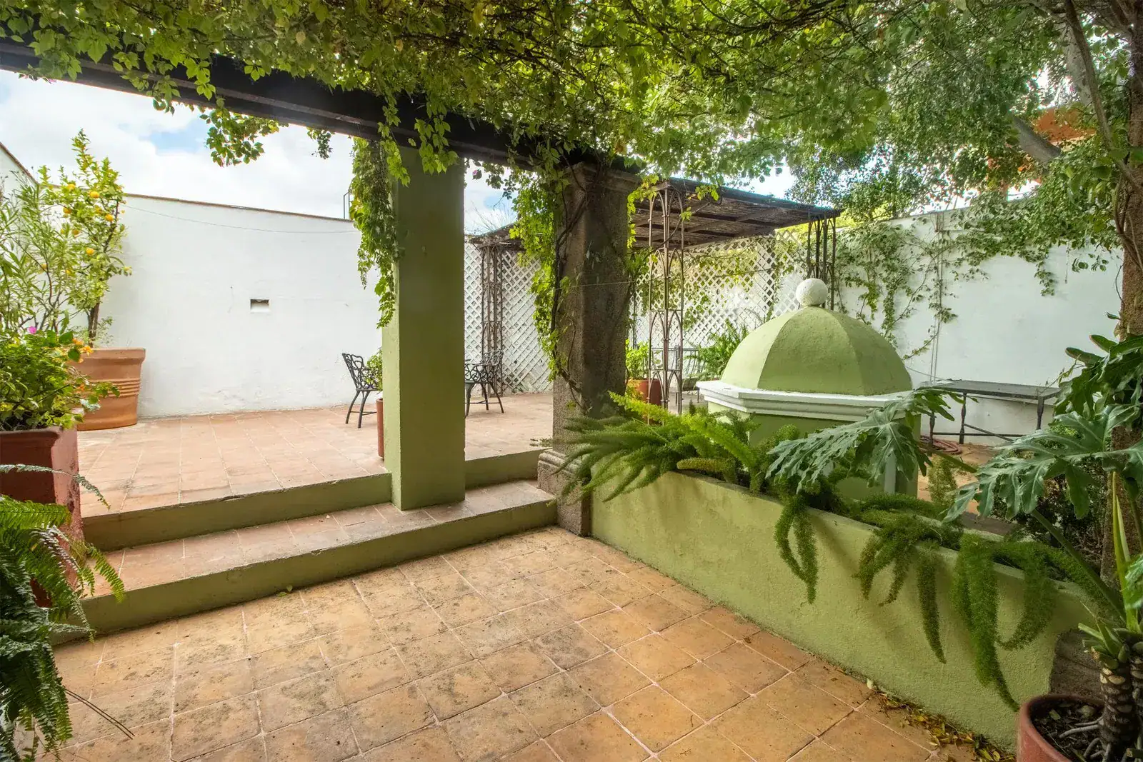 Casa Quetzal Hotel, terrace corner with a step up to a patio and a green dome beyond, San Miguel de Allende