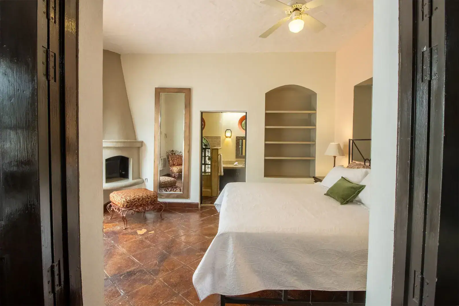 Casa Quetzal Hotel, bedroom with a corner fireplace, a long mirror and a bathroom beyond, San Miguel de Allende