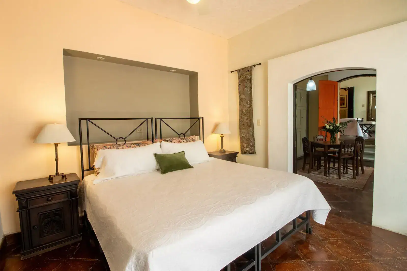Casa Quetzal Hotel, bedroom with a wrought-iron bed and an arched opening to the dining area, San Miguel de Allende