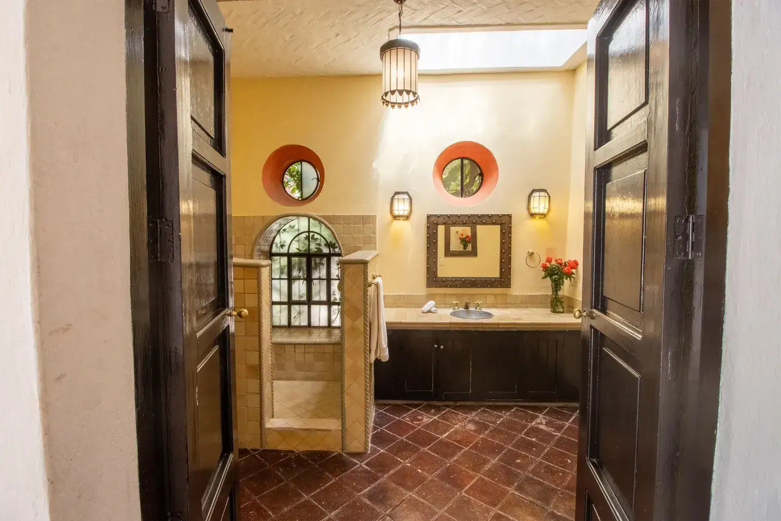 Casa Quetzal Hotel, bathroom with a round red window, tiled shower and an arched mirror, San Miguel de Allende