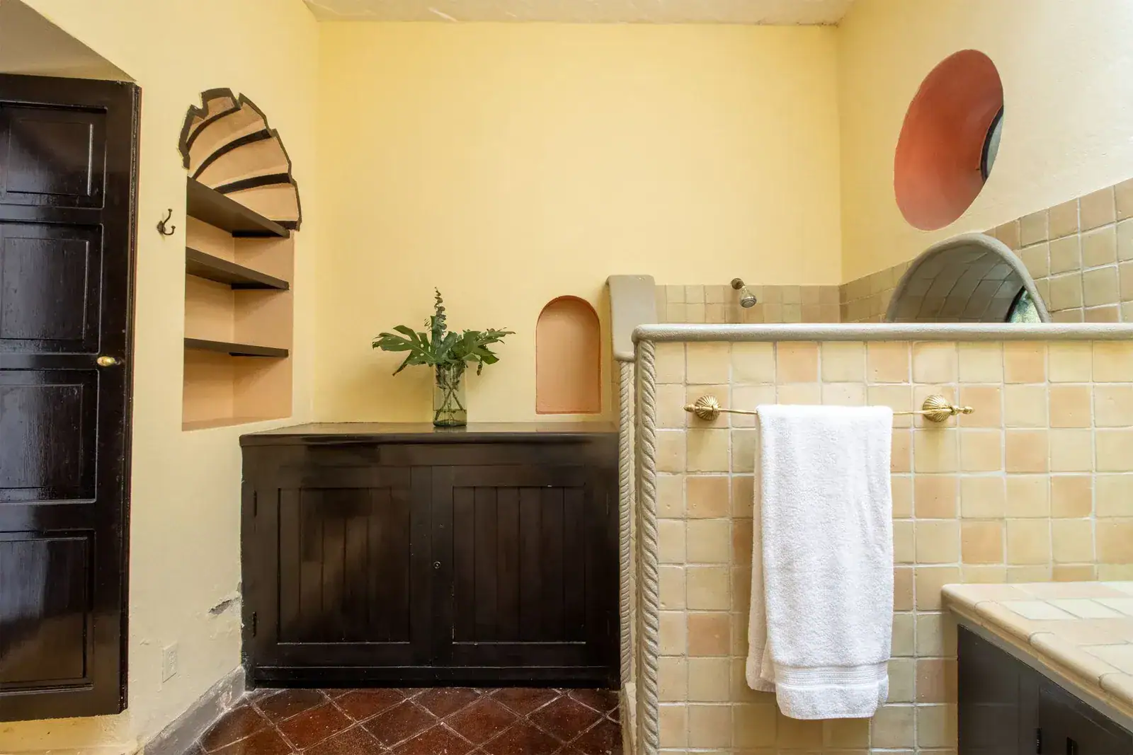 Casa Quetzal Hotel, bathroom with a tiled shower, dark wood cabinet and a towel, San Miguel de Allende
