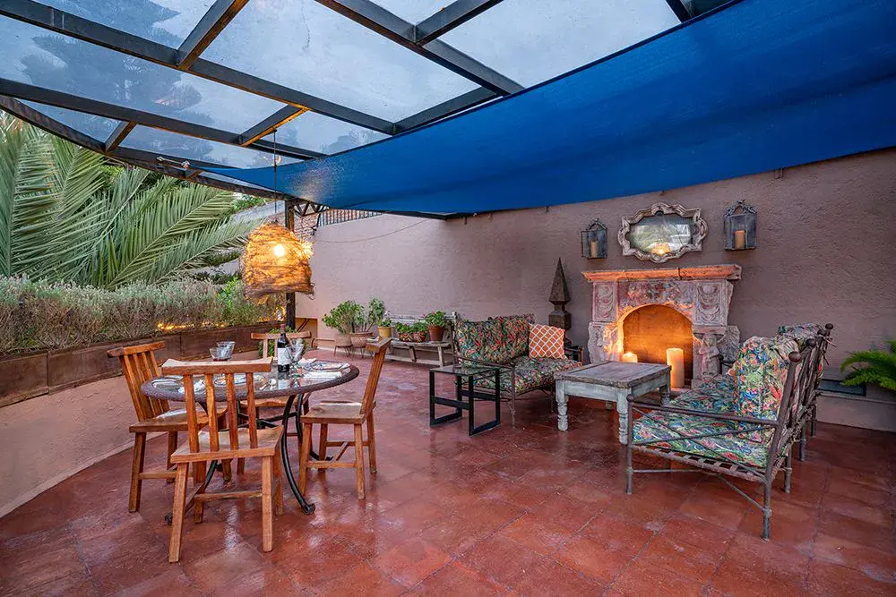 Casa Ro, rooftop terrace with a stone fireplace, a dining table and a glass canopy, San Miguel de Allende