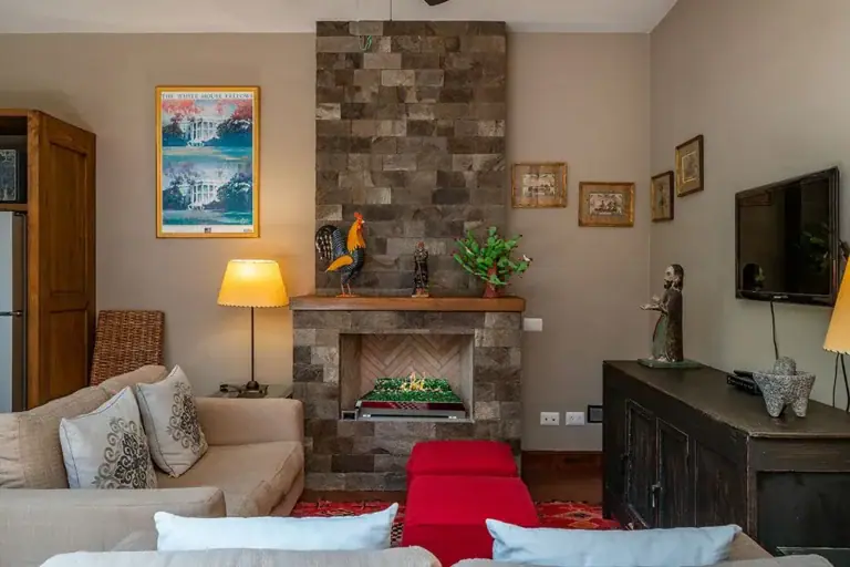 Casa Ro, living area with a stone fireplace and white sofas, San Miguel de Allende
