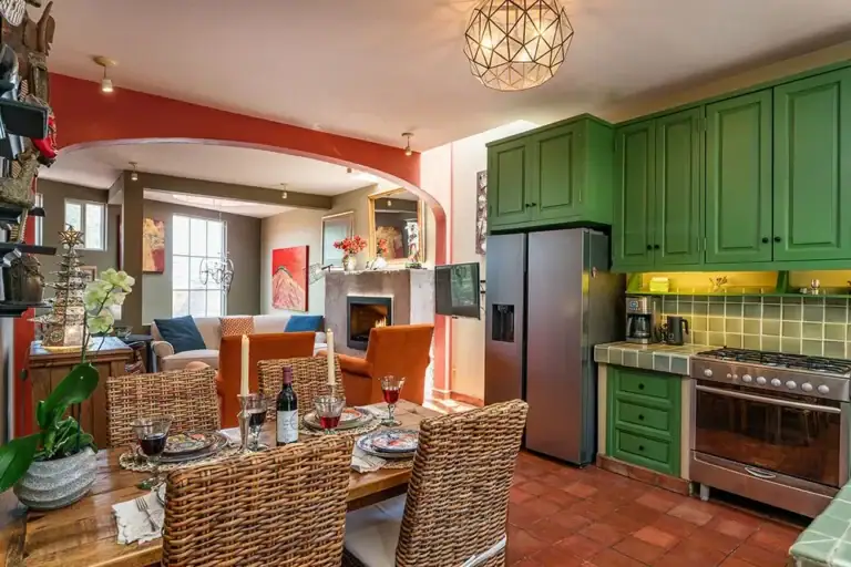 Casa Ro, kitchen with green cabinets and a wood dining table, San Miguel de Allende