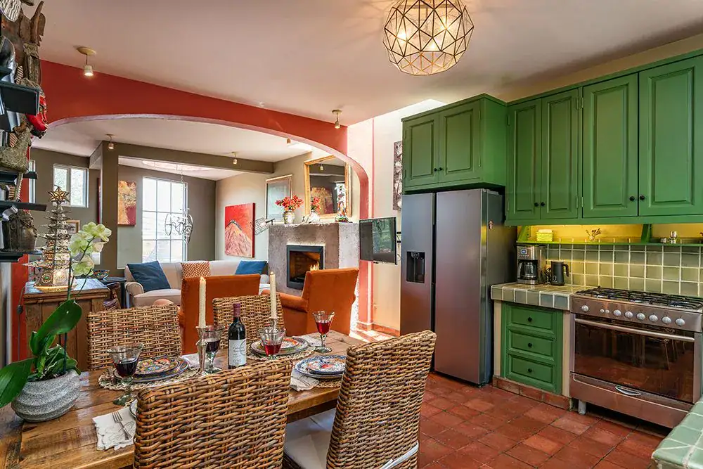 Casa Ro, kitchen with green cabinets and a wood dining table, San Miguel de Allende