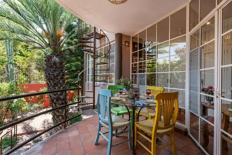 Casa Ro, balcony breakfast table with colorful chairs and a spiral staircase, San Miguel de Allende