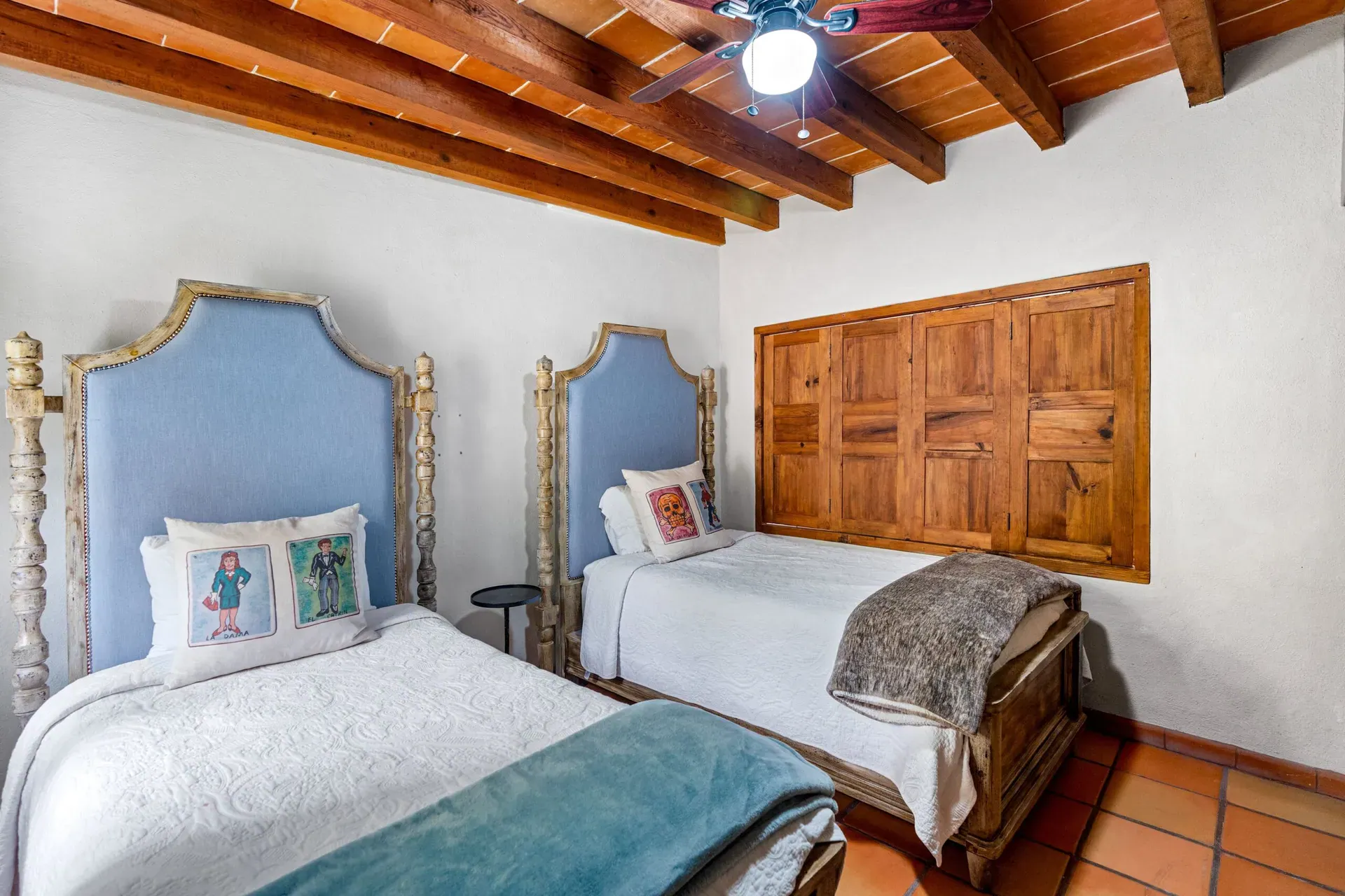 Casa Roka, twin bedroom with blue headboards, a wood closet and a teal blanket, San Miguel de Allende