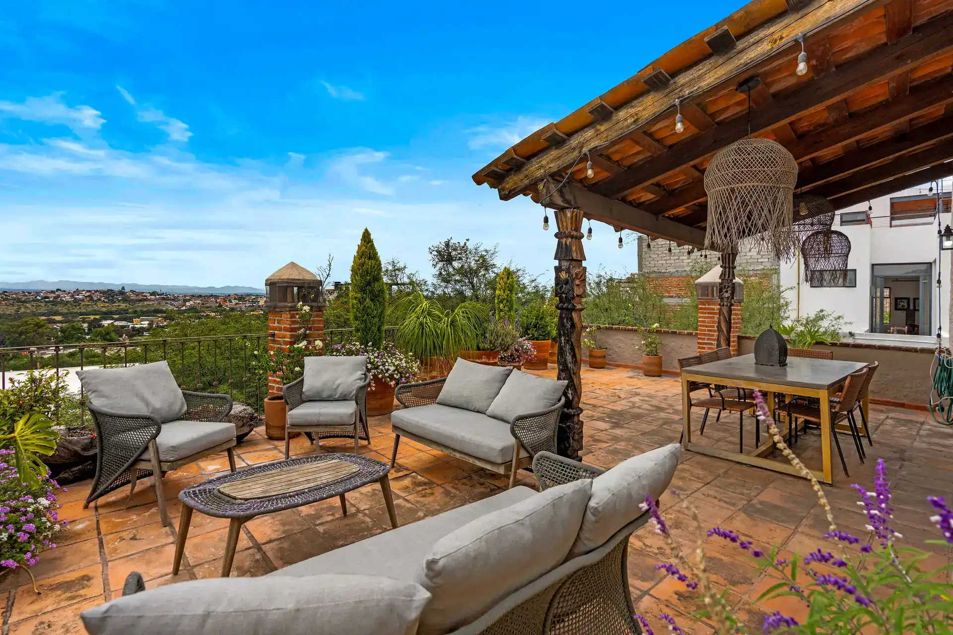 Casa Roka, rooftop terrace with a wood pergola, a wicker lounge set, a dining table and views of the town, San Miguel de Allende
