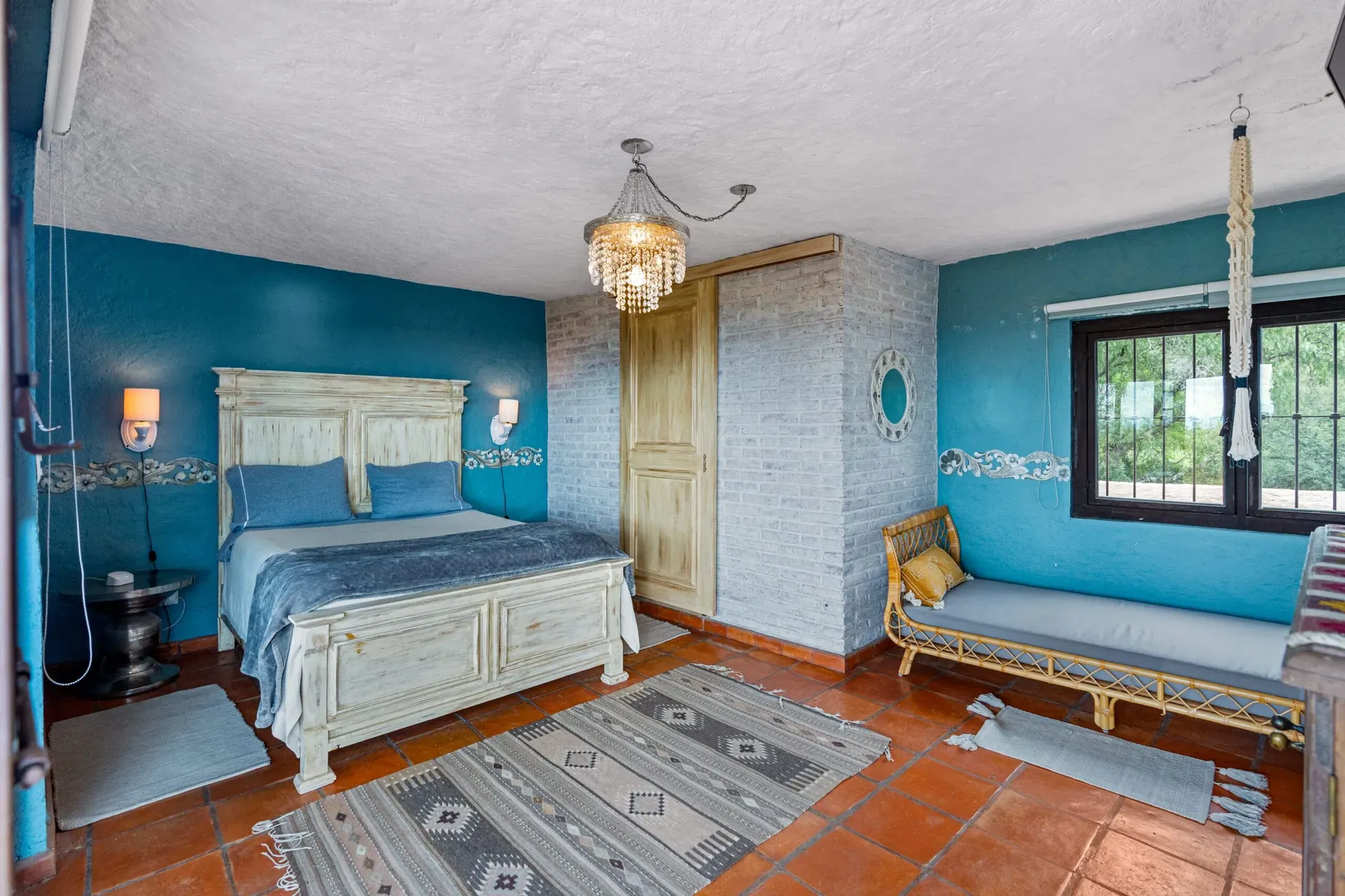 Casa Roka, bedroom with blue walls, a white wood bed, a blue daybed and a crystal chandelier, San Miguel de Allende