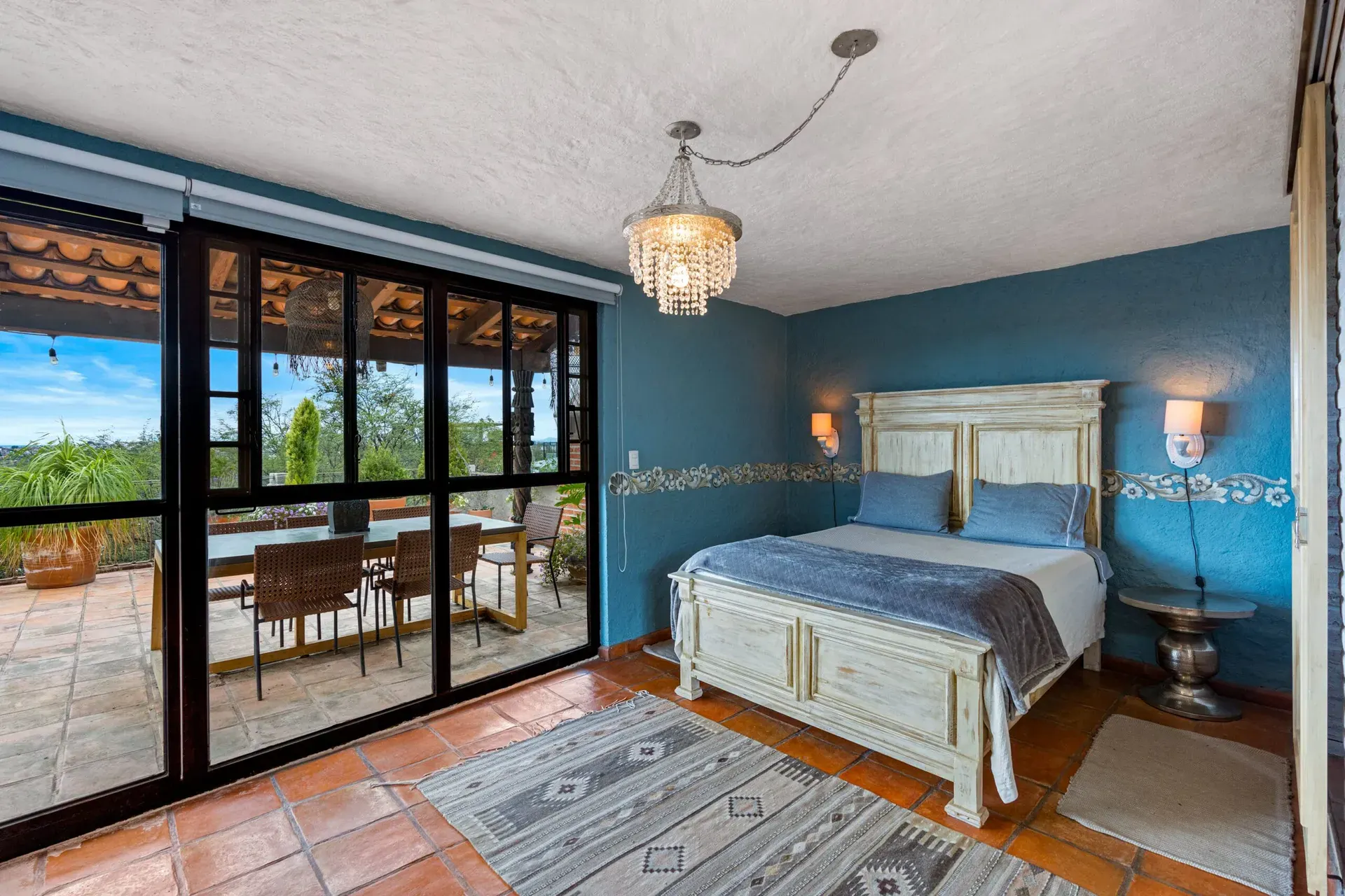 Casa Roka, bedroom with glass doors to the terrace, a white wood bed and a blue textured wall, San Miguel de Allende