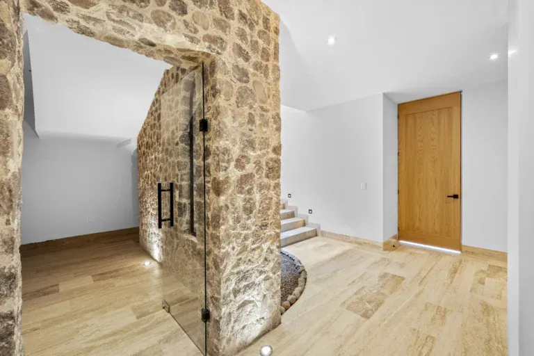 Casa Ronda, empty hall with a stone portal with a glass door, a wood door and stairs going up, San Miguel de Allende
