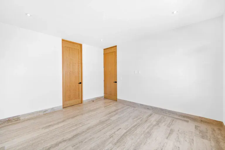 Casa Ronda, empty room with two wood doors and a pale wood floor, San Miguel de Allende
