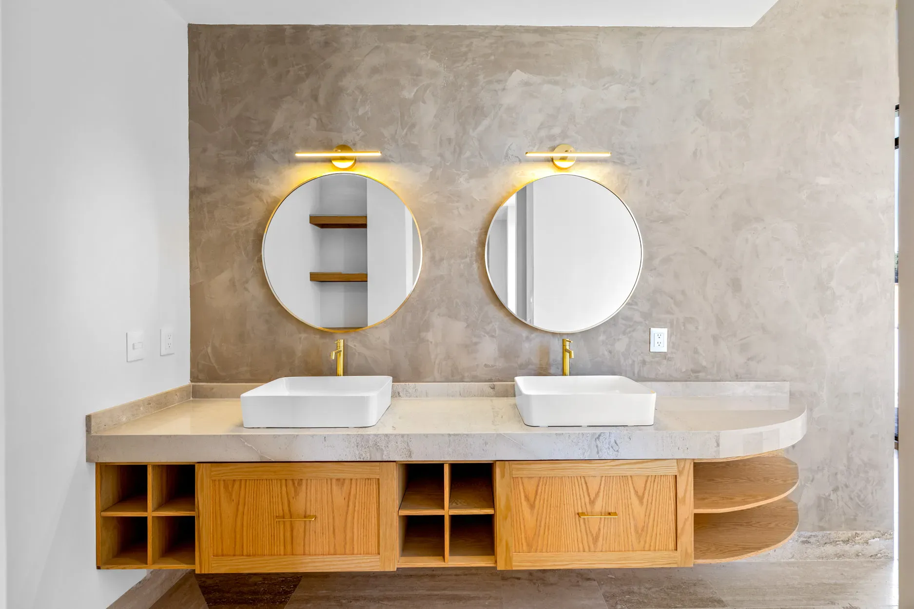 Casa Ronda, bathroom with a floating wood double vanity, two vessel sinks and round gold mirrors, San Miguel de Allende