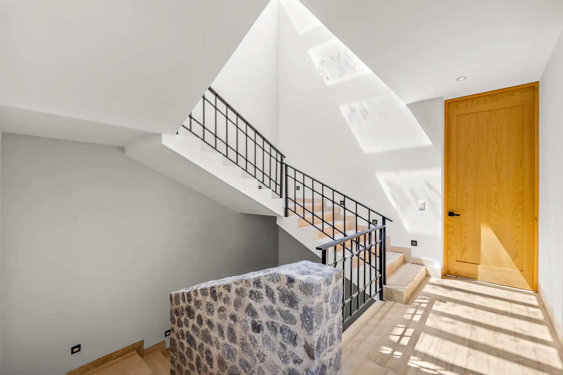Casa Ronda, stairwell with an iron railing, a stone wall and a wood door, San Miguel de Allende
