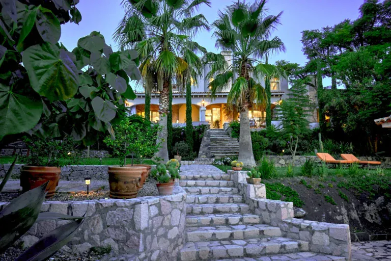 Casa Rosa, stone garden steps among palms and tropical plants at dusk, San Miguel de Allende