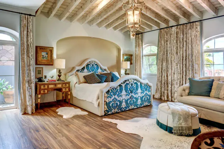 Casa Rosa, bedroom with a blue upholstered headboard and arched windows, San Miguel de Allende