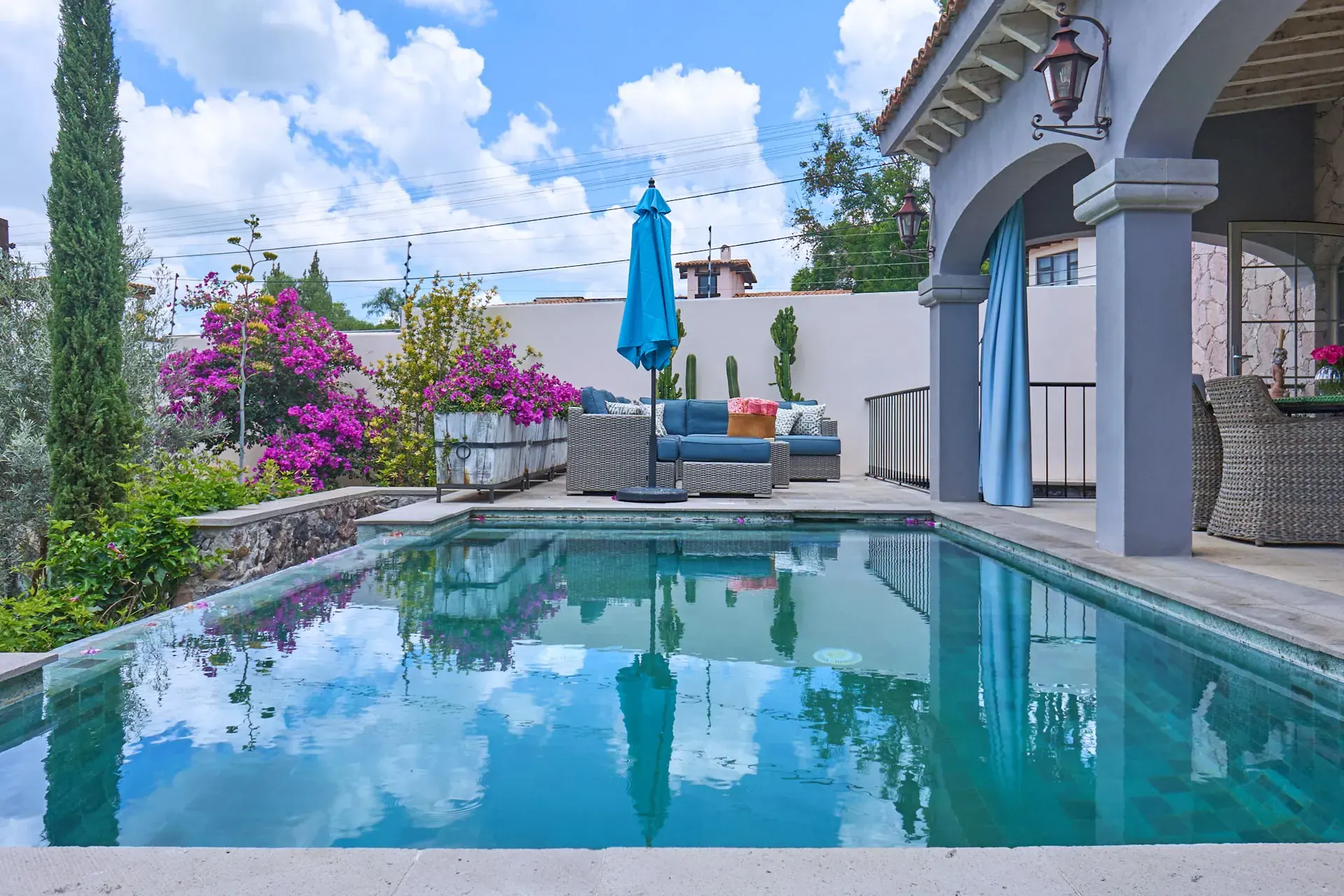 Casa Rosa, pool reflecting the sky beside an arcade and a lounge terrace, San Miguel de Allende