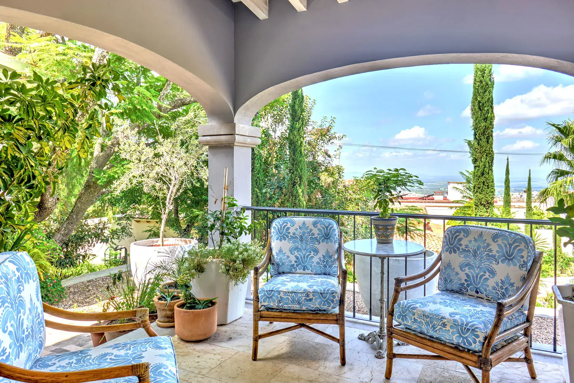 Casa Rosa, covered balcony with blue cushioned chairs and a valley view, San Miguel de Allende