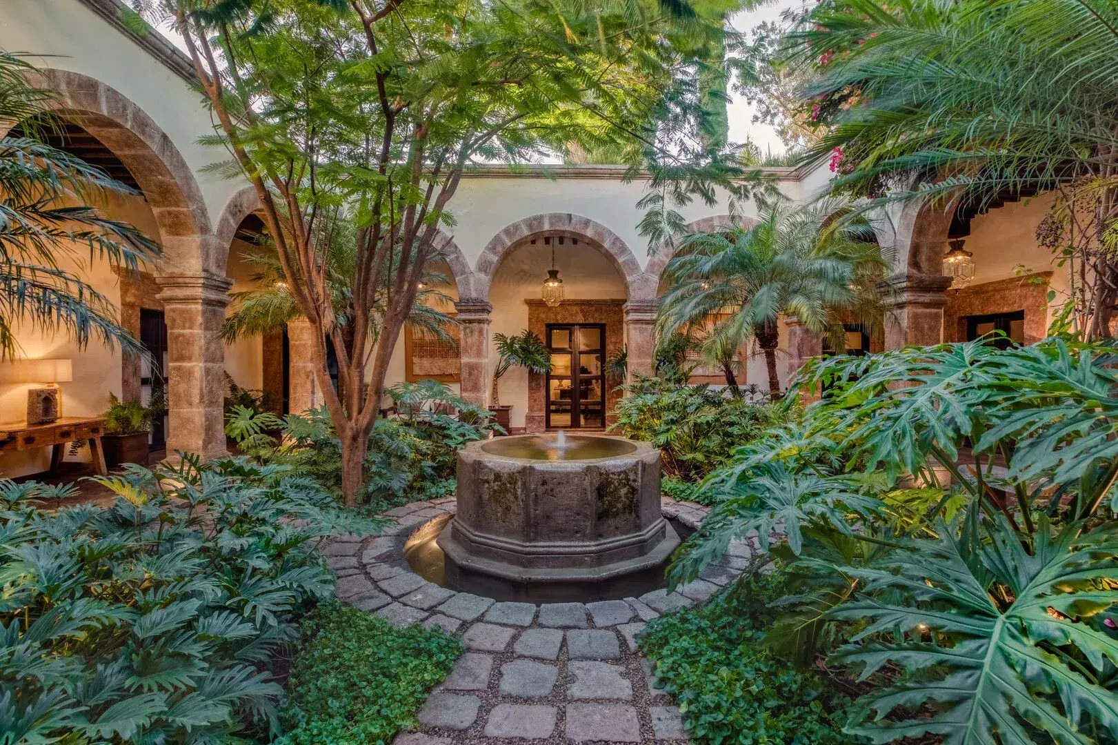 Casa San Jose, interior courtyard with a stone fountain and tropical plants, San Miguel de Allende