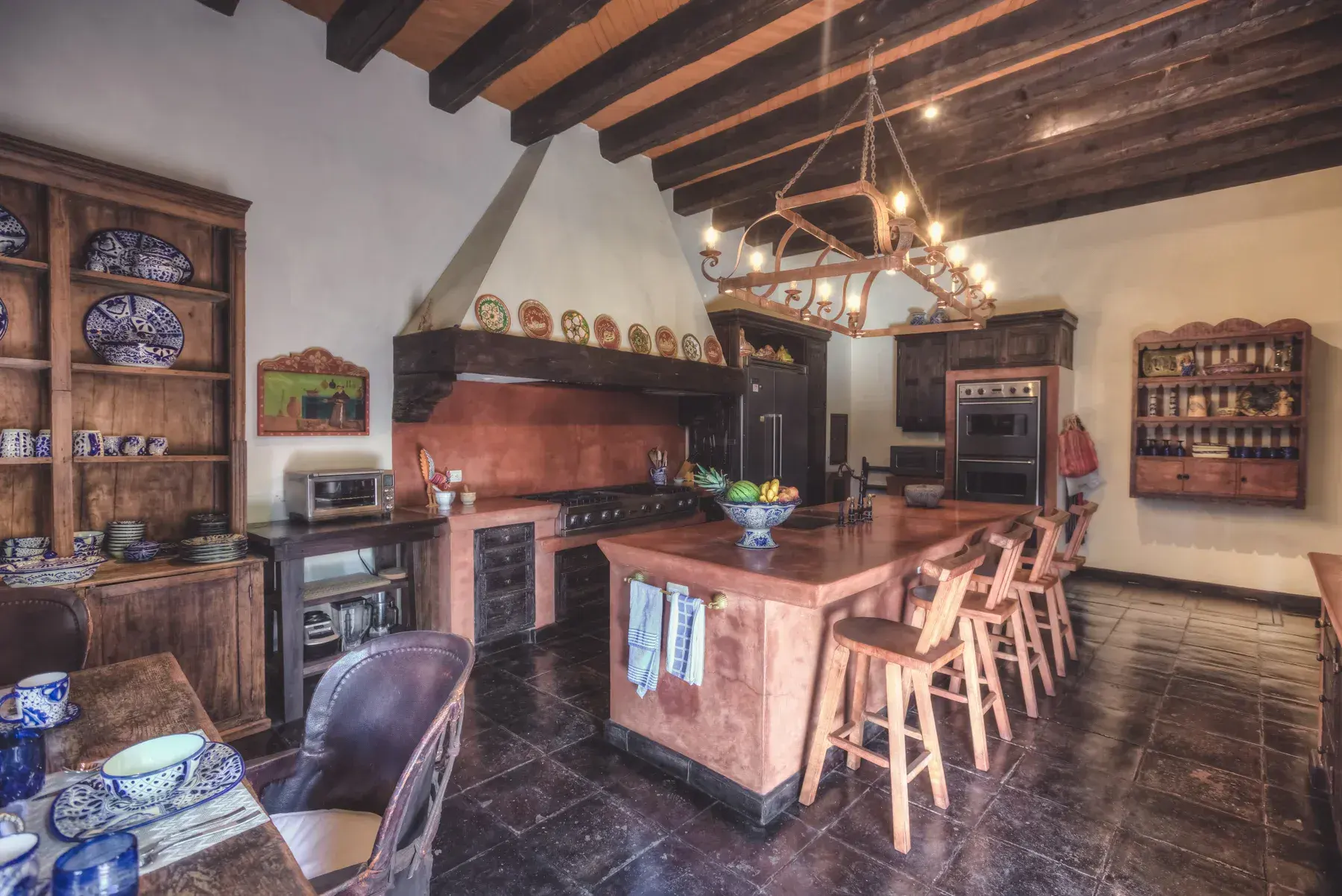 Casa San Jose, kitchen with a copper island, bar stools and a wood beam ceiling, San Miguel de Allende