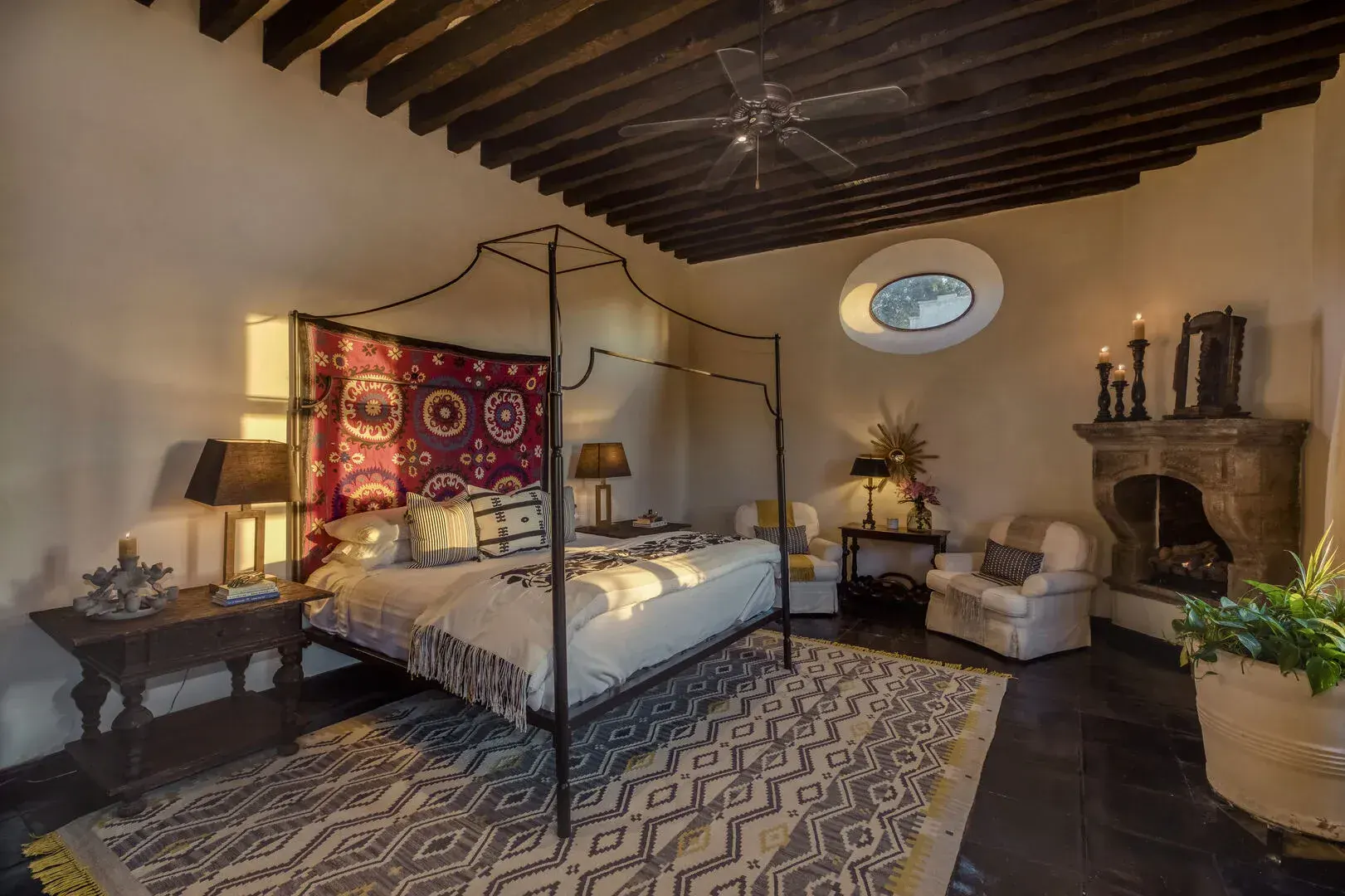 Casa San Jose, bedroom with a canopy bed, fireplace and a patterned rug, San Miguel de Allende