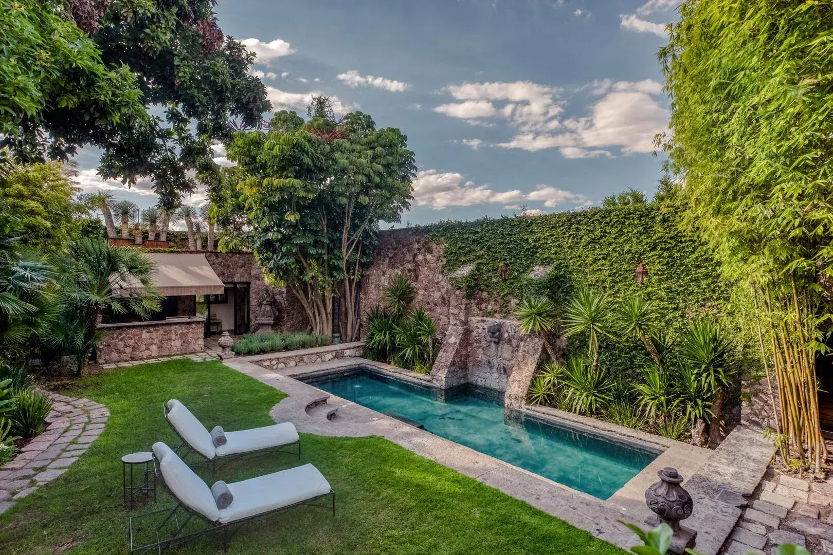 Casa San Jose, walled garden with a lawn, lounge chairs and a narrow pool, San Miguel de Allende