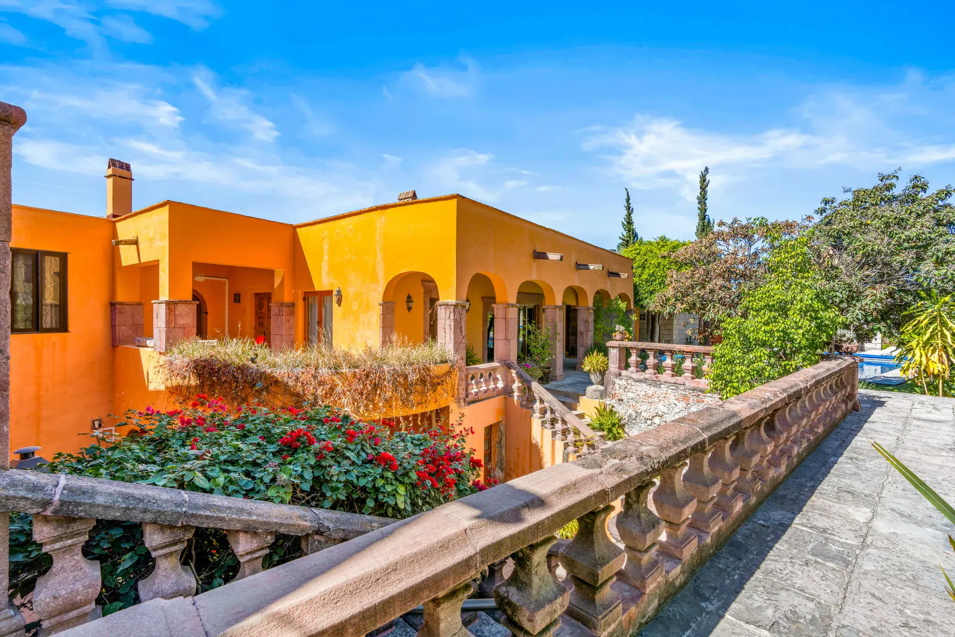 Casa San Rafael, orange arcaded house above a flower-filled balustrade, San Miguel de Allende