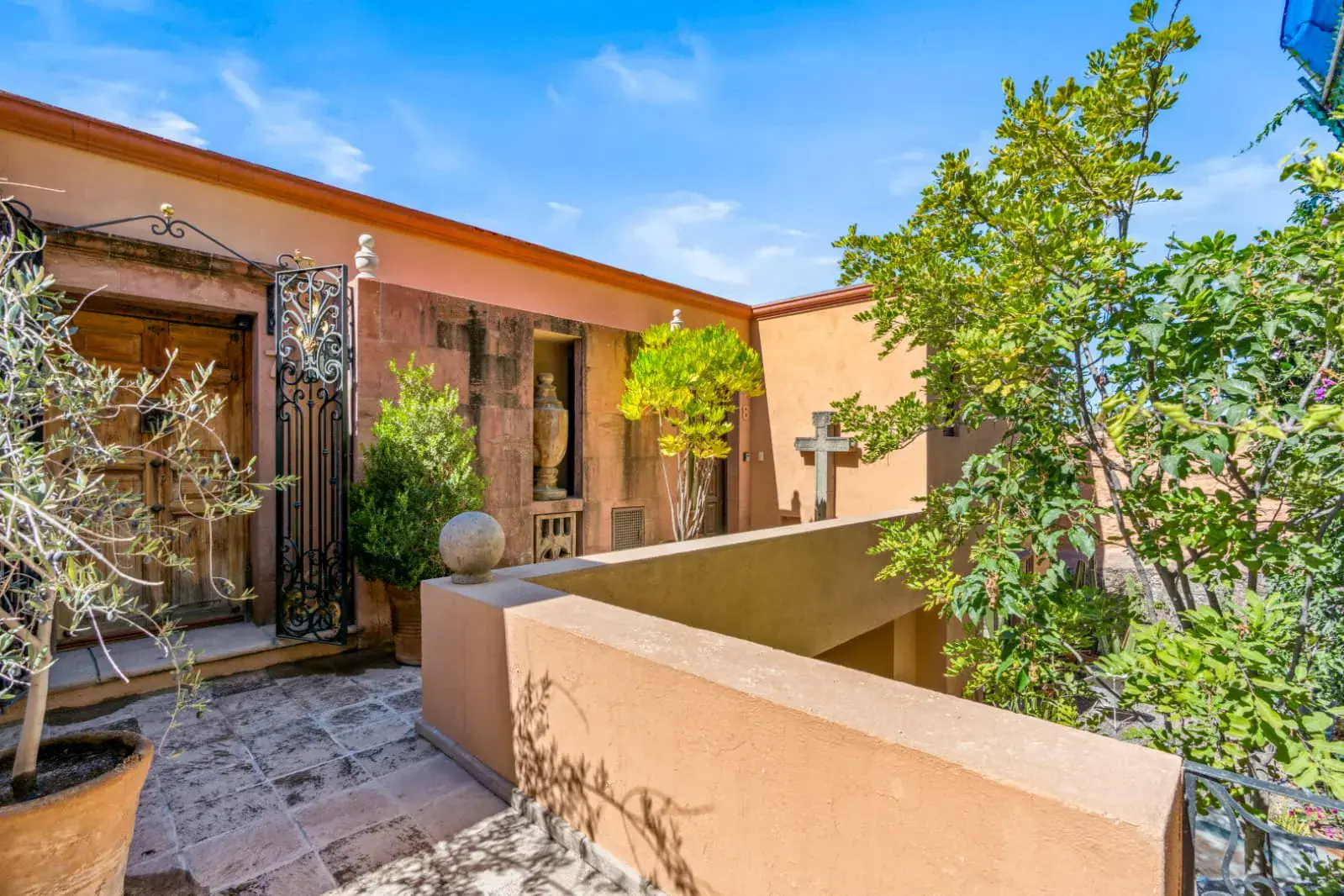Casa San Rafael, entry courtyard with a carved wood door and olive trees, San Miguel de Allende
