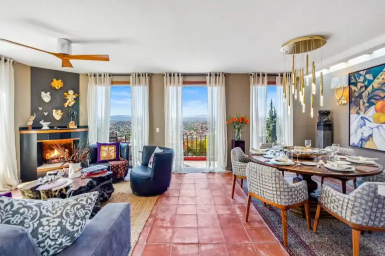 Casa San Rafael, living and dining room with a fireplace and a view over the city, San Miguel de Allende