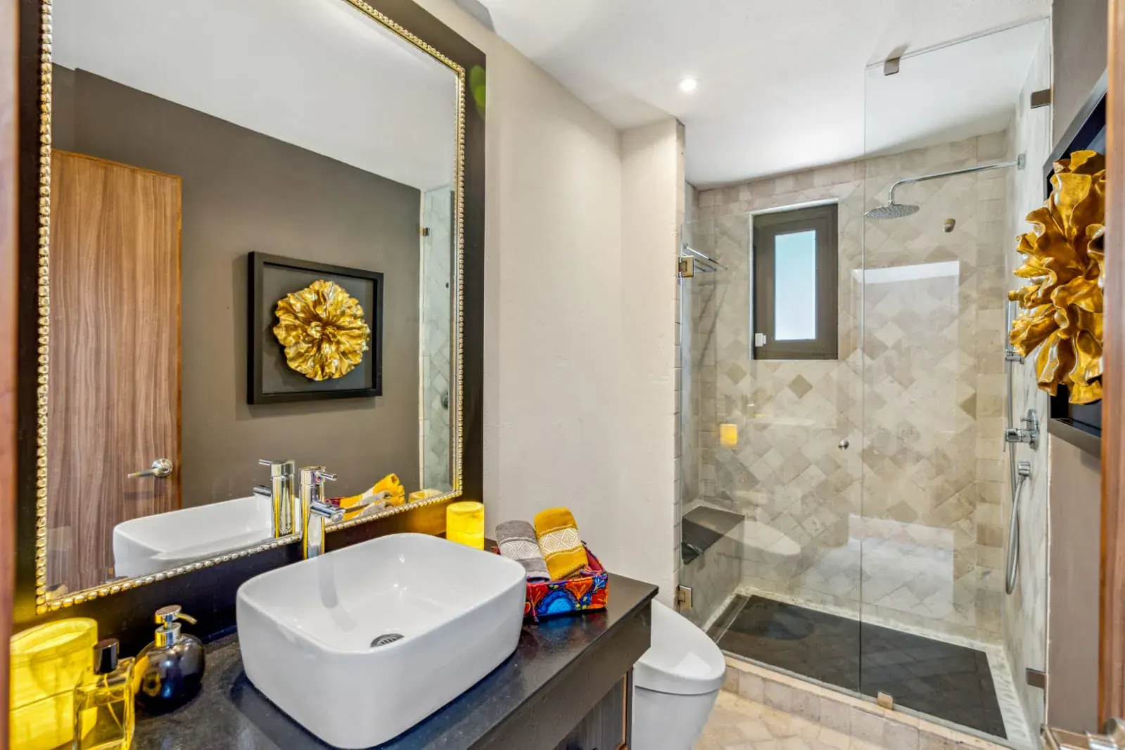 Casa San Rafael, bathroom with a vessel sink, a gold wall flower and a glass shower, San Miguel de Allende