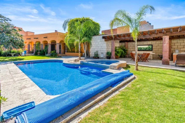 Casa San Rafael, lit pool with a lawn at dusk beside the arcaded building, San Miguel de Allende