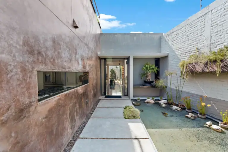 Casa Sanchez Renero, entry courtyard with a copper-toned wall, a shallow reflecting pond and stepping-stone paving leading to the front door, San Miguel de Allende