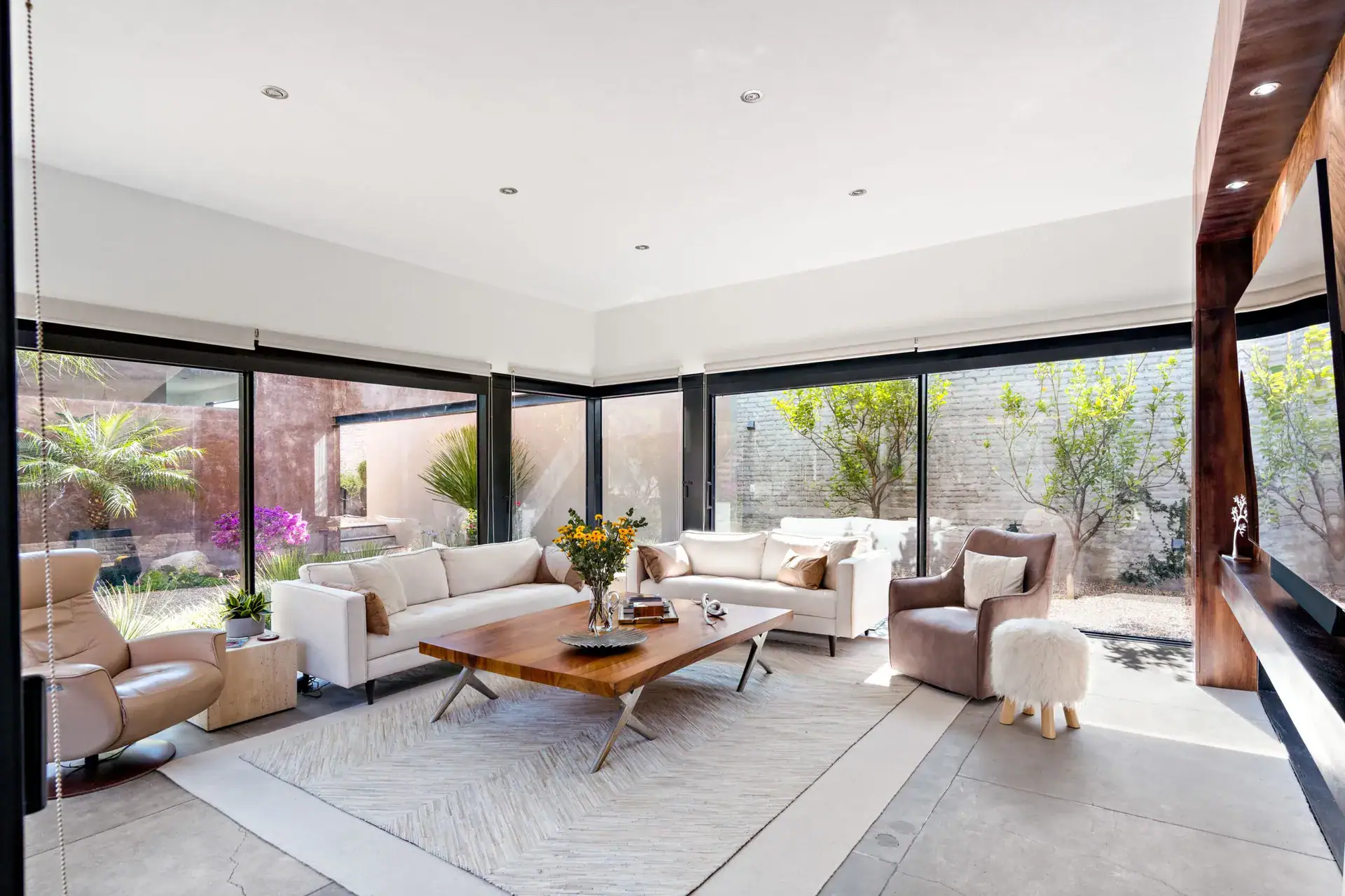 Casa Sanchez Renero, living room with white sofas, a live-edge wood coffee table and sliding glass walls to the courtyard, San Miguel de Allende