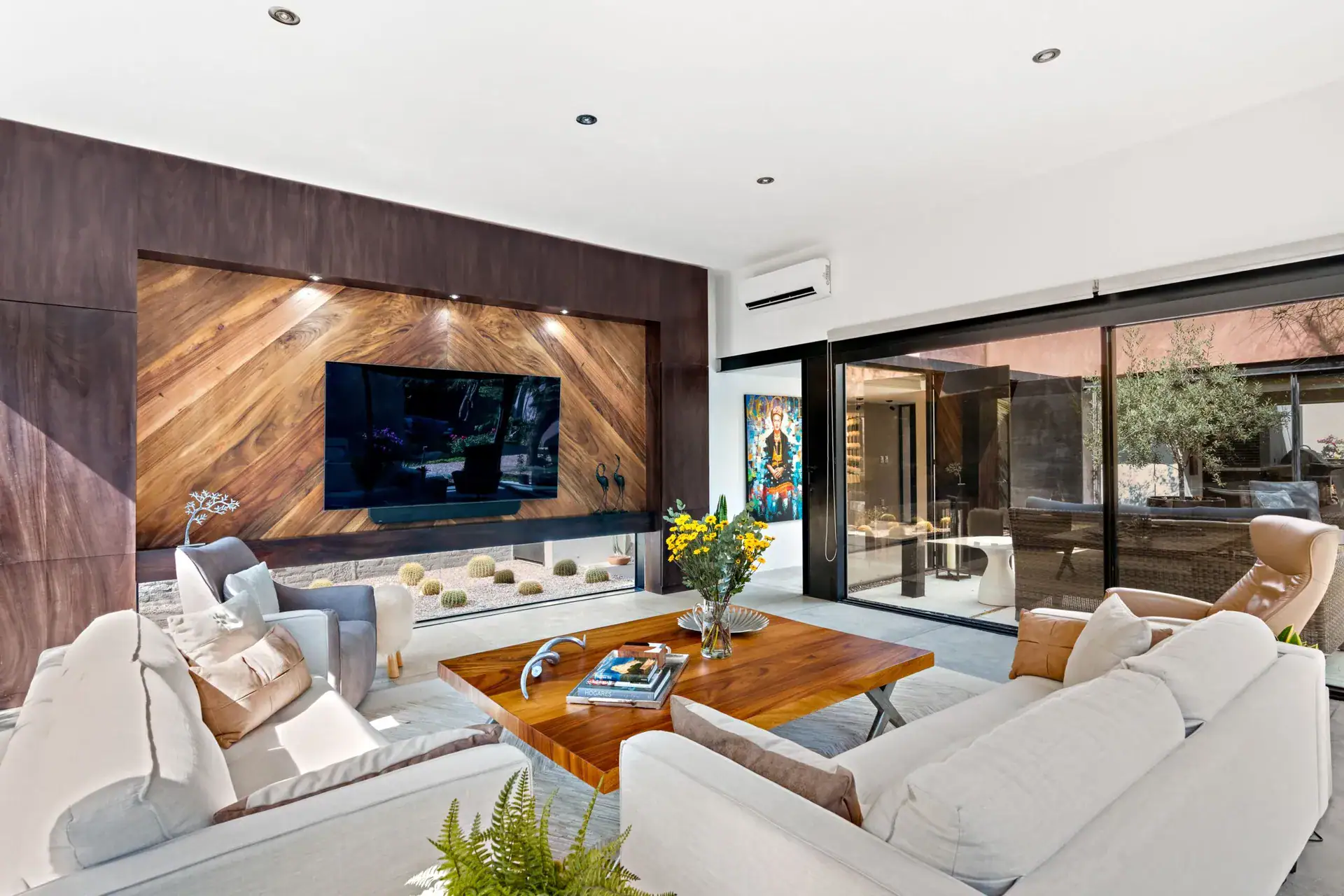 Casa Sanchez Renero, living room with a wood-paneled television wall and a corten steel surround beside a cactus planter, San Miguel de Allende