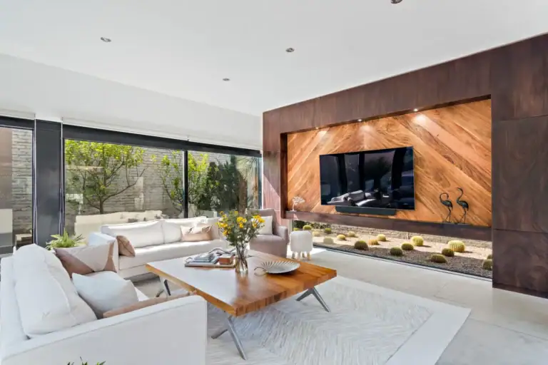 Casa Sanchez Renero, living room with white sofas and a coffee table in front of the wood-clad television wall, San Miguel de Allende