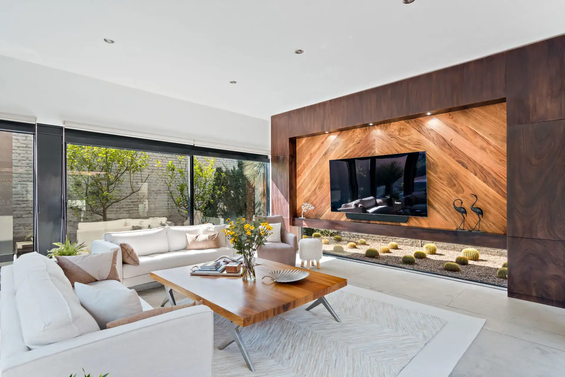 Casa Sanchez Renero, living room with white sofas and a coffee table in front of the wood-clad television wall, San Miguel de Allende