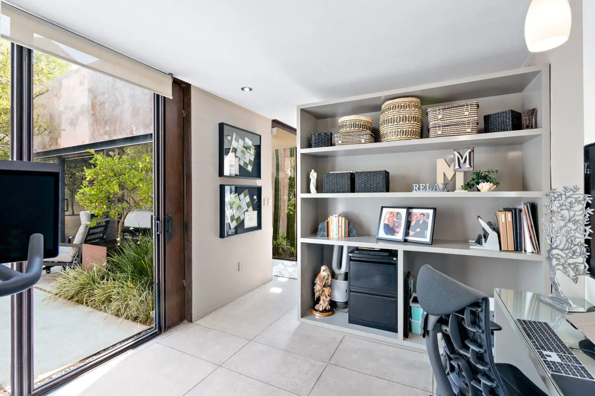 Casa Sanchez Renero, office with built-in shelves, a desk, a framed floral print and a sliding glass door, San Miguel de Allende