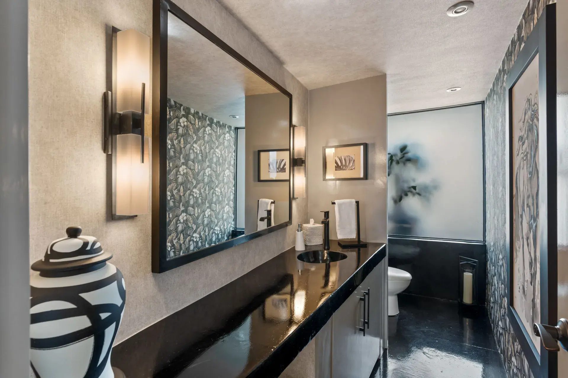 Casa Sanchez Renero, powder room with a black counter, a framed mirror and a frosted glass panel, San Miguel de Allende