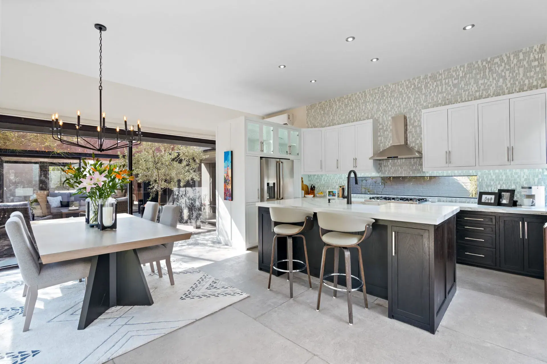 Casa Sanchez Renero, dining table and kitchen island with bar stools and a wrought-iron chandelier, San Miguel de Allende