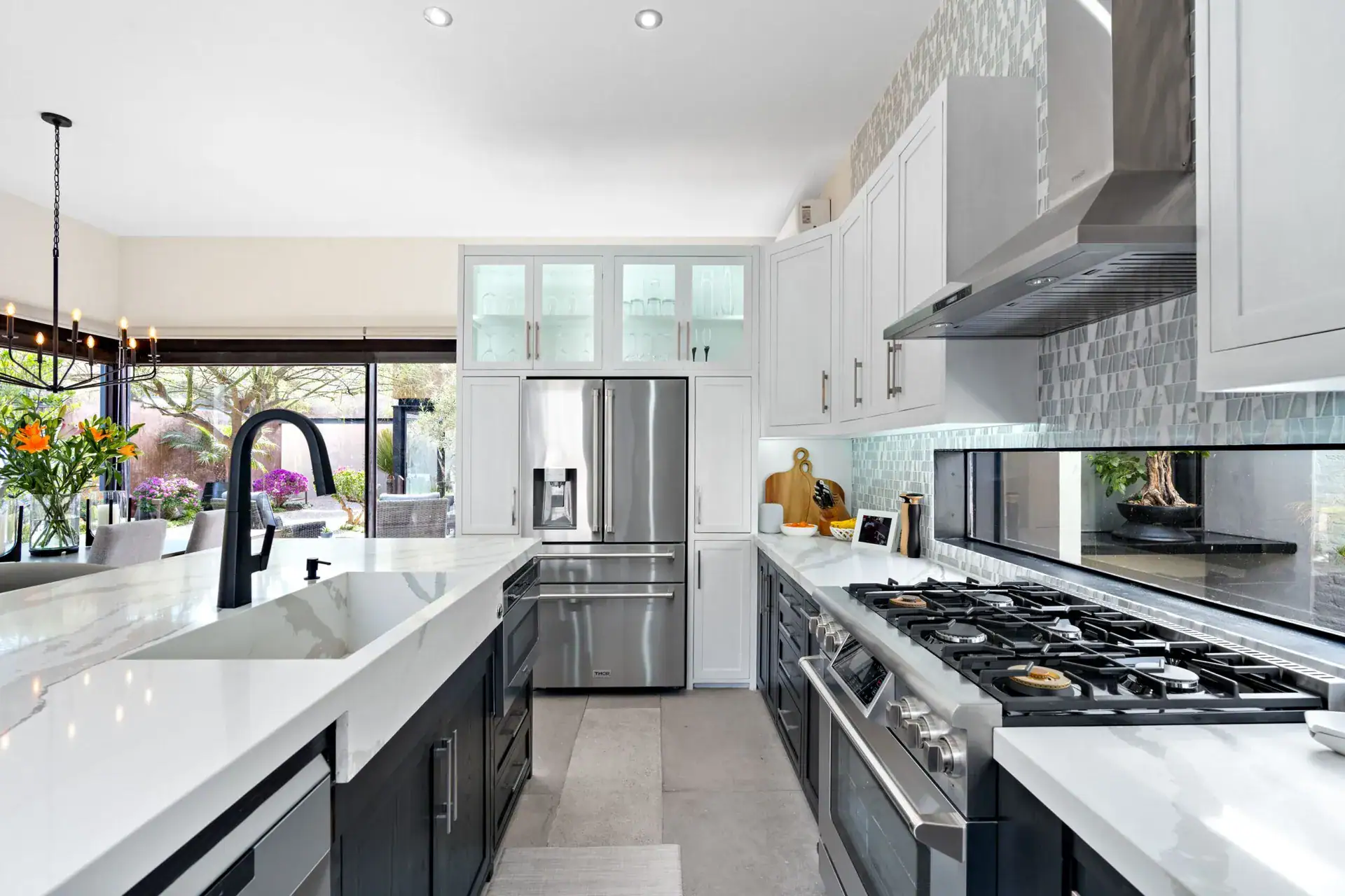 Casa Sanchez Renero, kitchen with a stainless gas range, white cabinets, glass-front uppers and a quartz island, San Miguel de Allende