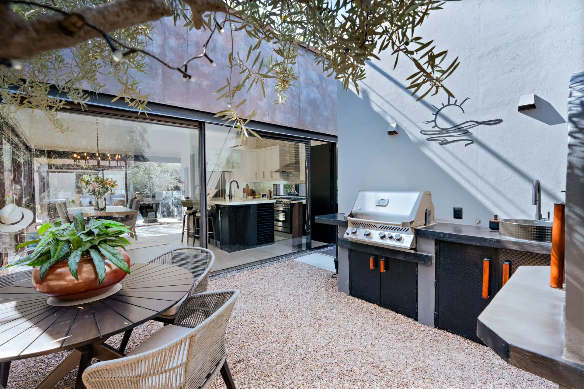 Casa Sanchez Renero, patio with an outdoor kitchen and a view through an open glass wall into the kitchen, San Miguel de Allende