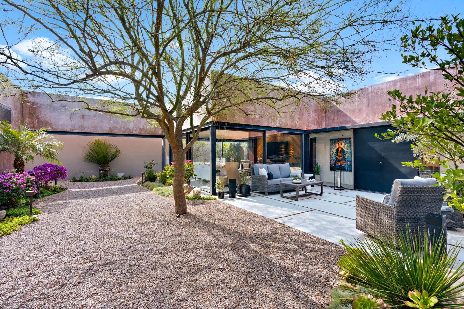 Casa Sanchez Renero, gravel courtyard with a large tree, a lounge area and bougainvillea, San Miguel de Allende
