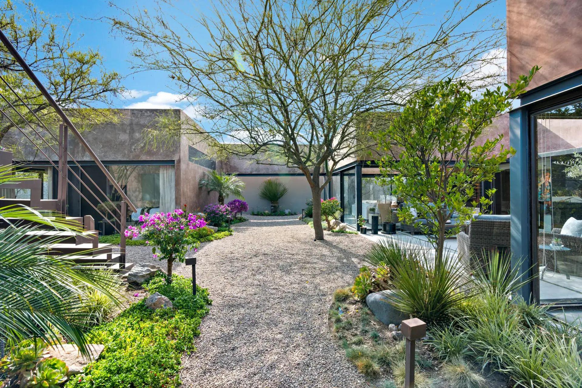 Casa Sanchez Renero, desert garden with a gravel path, flowering shrubs and a steel staircase, San Miguel de Allende