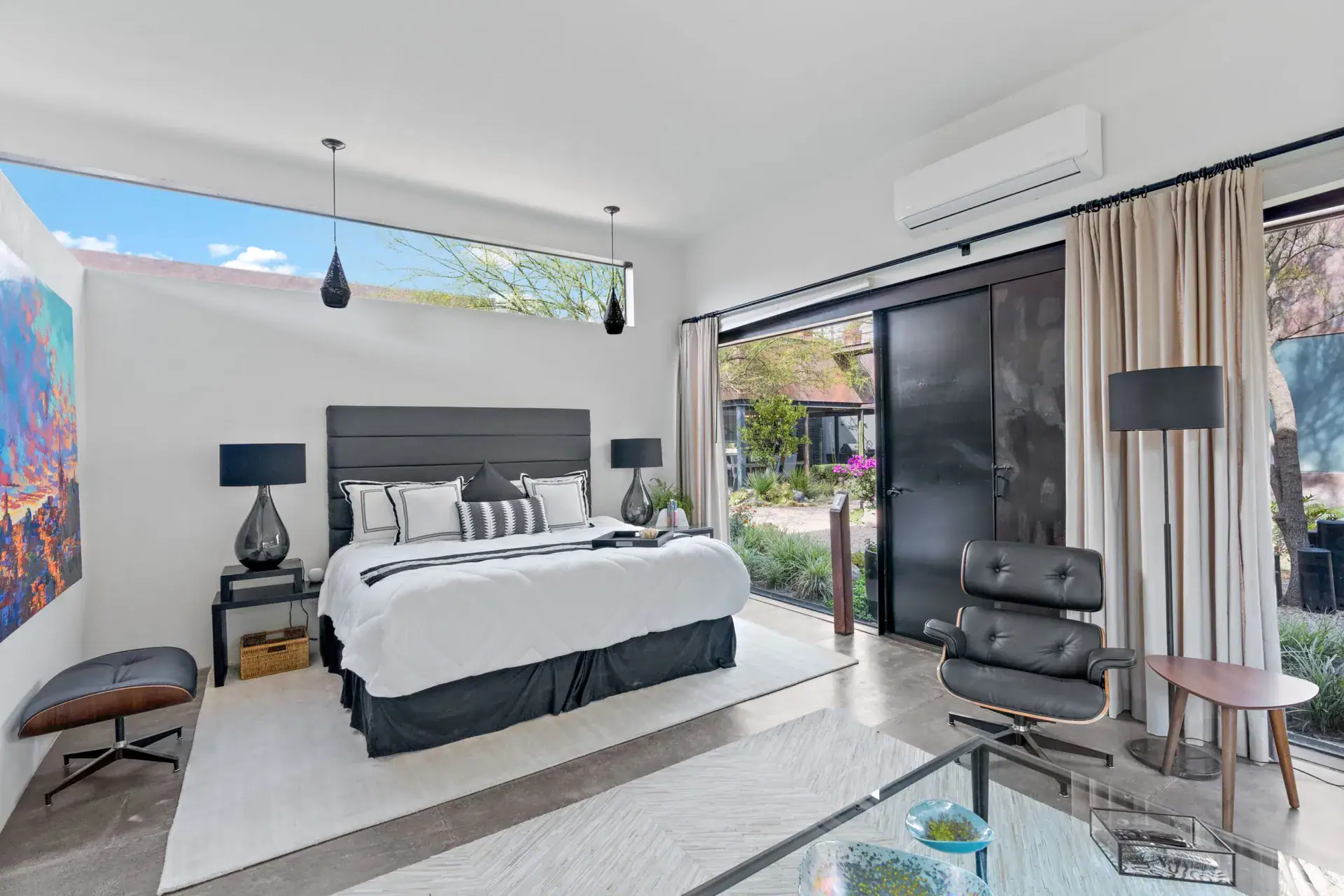 Casa Sanchez Renero, bedroom with a king bed, a leather chair and a glass door to the garden, San Miguel de Allende