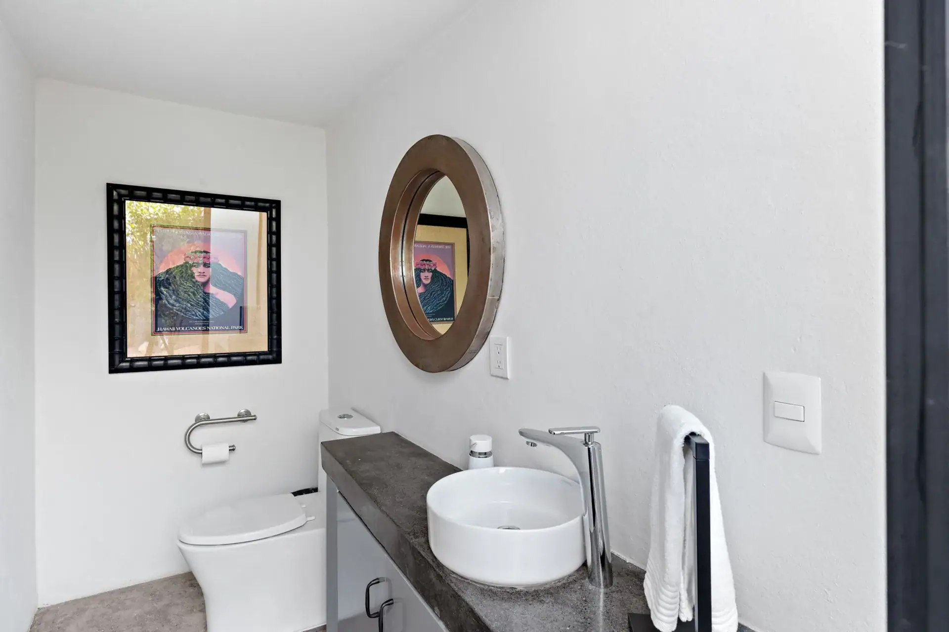 Casa Sanchez Renero, powder room with a white round vessel sink, a round framed mirror and a framed painting, San Miguel de Allende