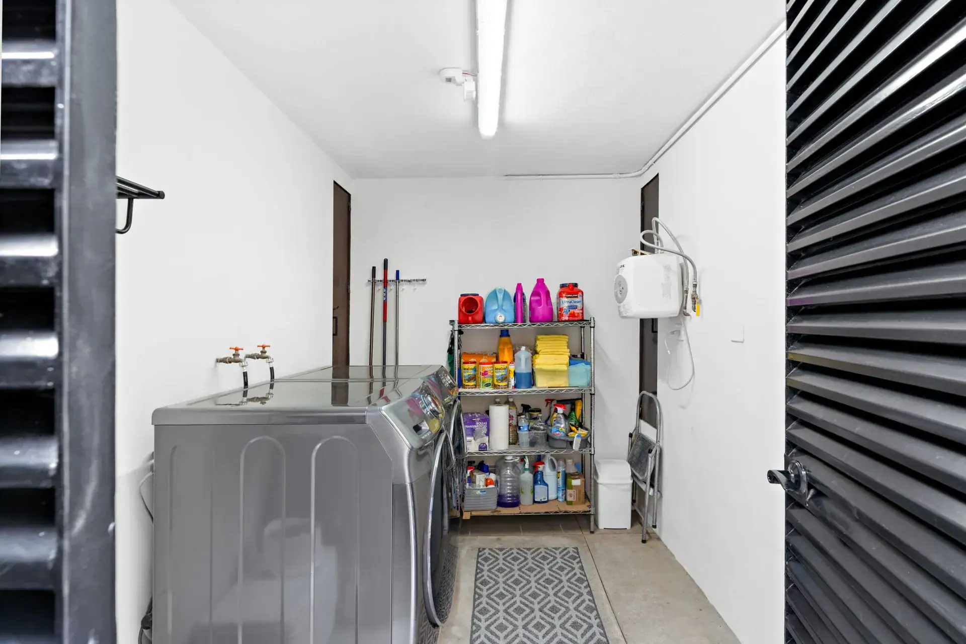 Casa Sanchez Renero, utility room with a washer and dryer, a storage shelf and a patterned rug, San Miguel de Allende