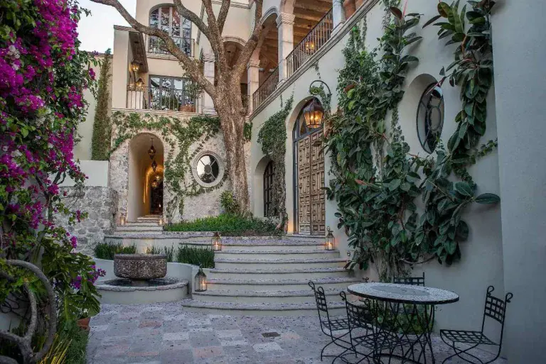 Casa Sereno, courtyard with a stone staircase, round table and bougainvillea, San Miguel de Allende